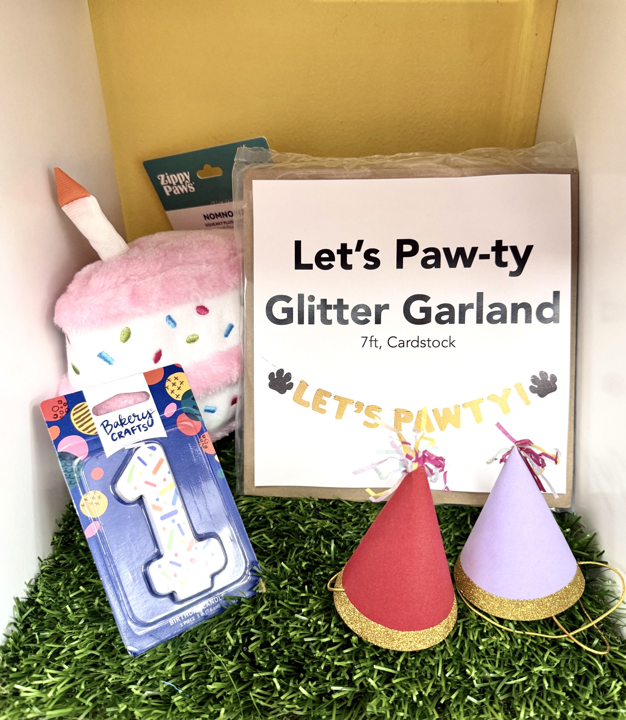 Birthday decorations and toys - party hats, glitter garland, number candle and cupcake plush